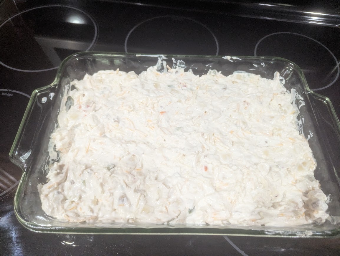 Uncooked hashbrown casserole spread evenly in a glass baking dish